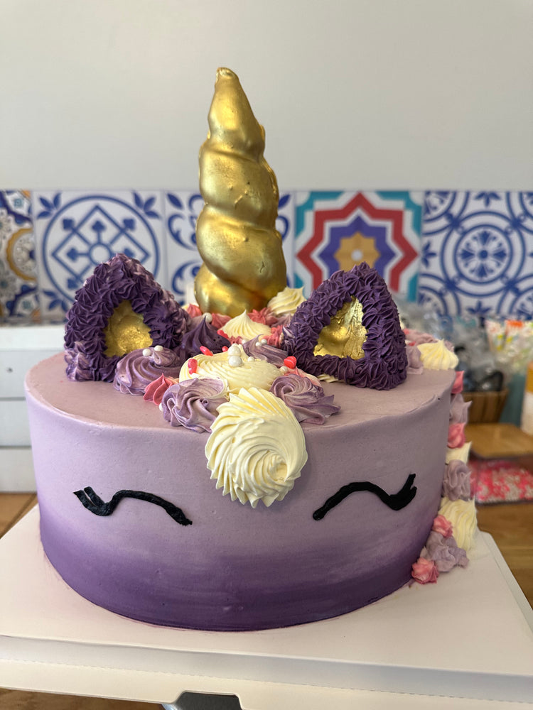 Unicorn cake with buttercream decoration purple and gold horn
