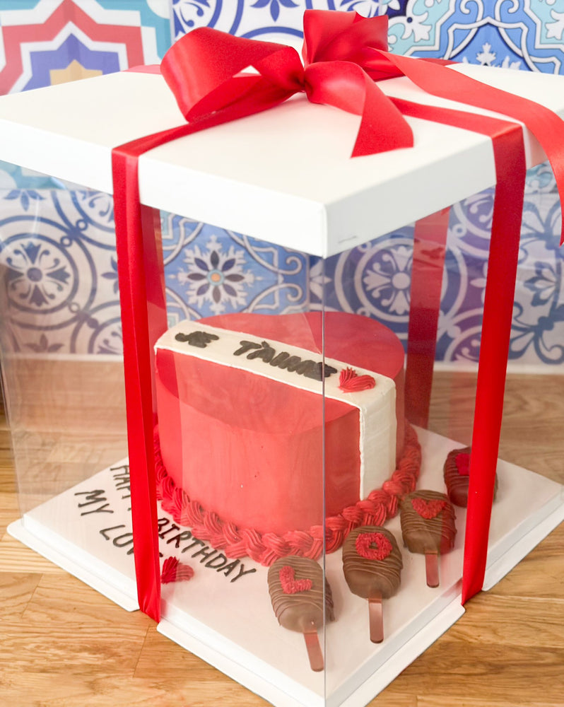 Heart shaped cake in a clear box with cakesickles